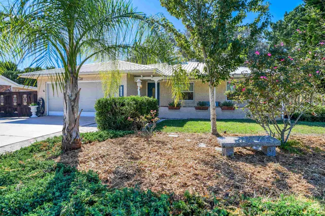 a view of a house with a backyard and tree