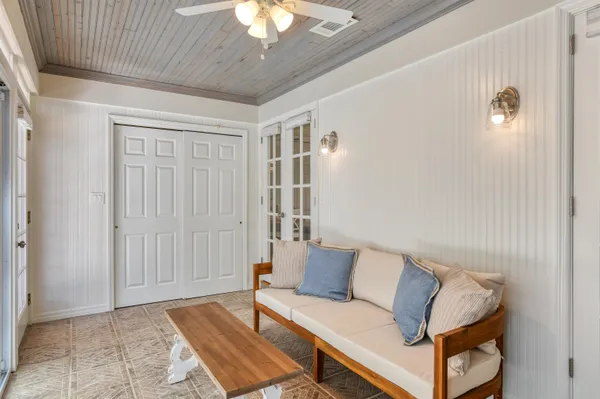 a view of a porch with chairs and potted plants