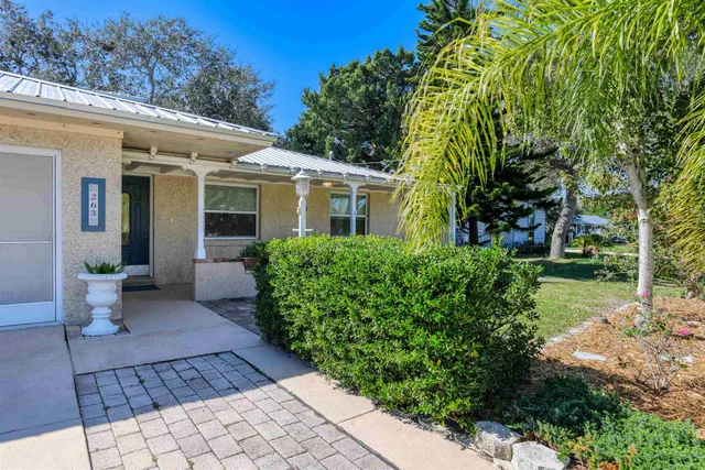 a view of a house with backyard sitting area and garden