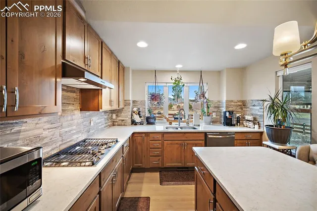 a kitchen with kitchen island granite countertop lots of counter top space and stainless steel appliances