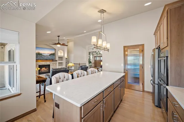 a large kitchen with kitchen island a stove a sink a refrigerator and a dining table