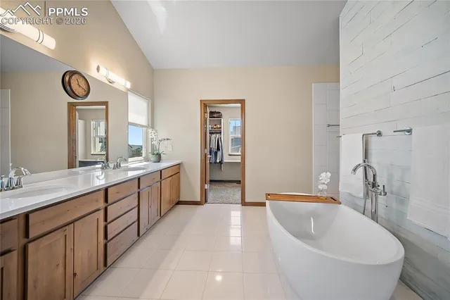 a large bathroom with a double vanity sink a mirror and a bathtub