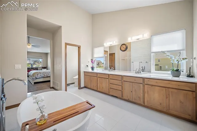a spacious en suite bathroom with a granite countertop sink and a mirror
