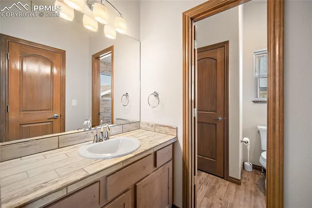 a bathroom with a granite countertop sink a mirror and a shower