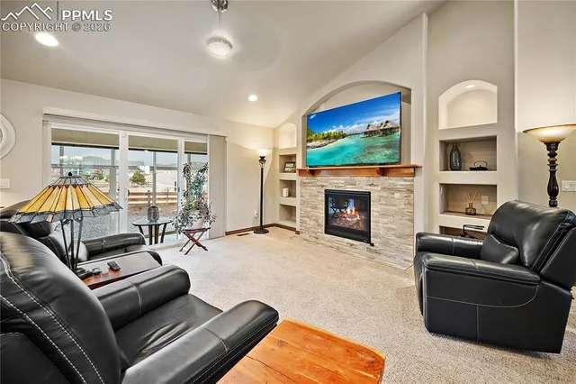a living room with furniture a flat screen tv and a fireplace