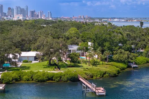 a view of an empty room with windows and chandelier fan