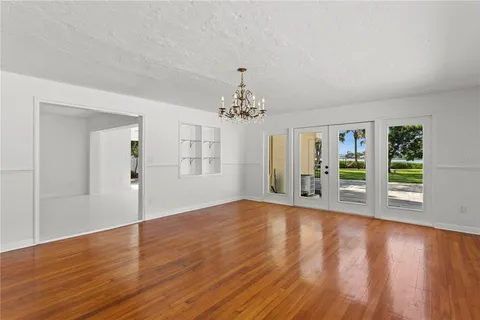 a view of an empty room and a ceiling fan & cabinets