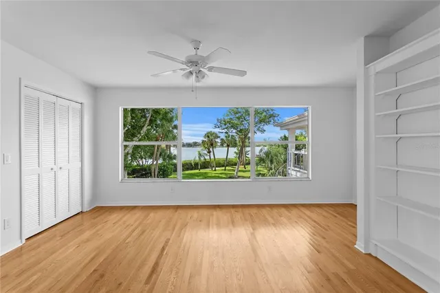 an empty room with closet and ceiling fan