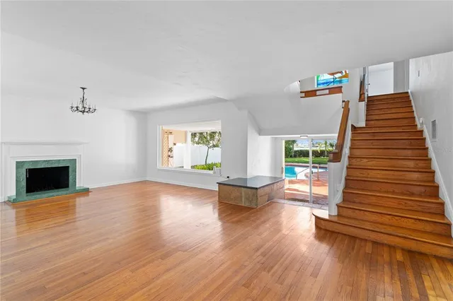 a view of empty room with wooden floor and fireplace