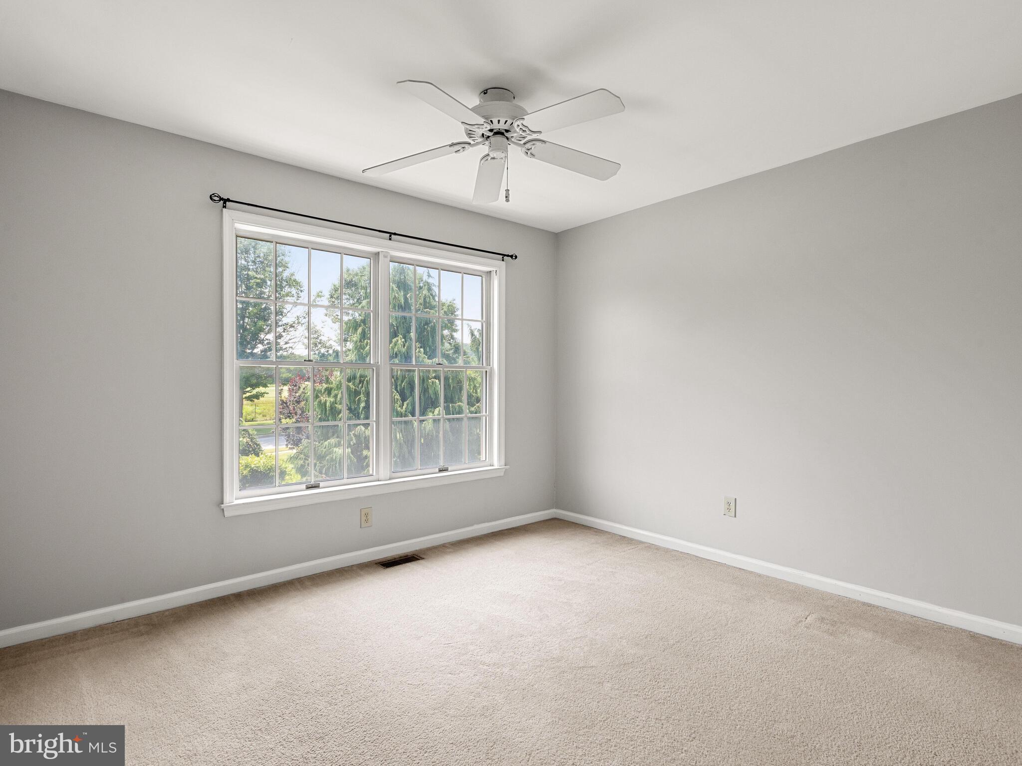 77 Buttonwood Drive, Unit 77 Exton, PA 19341 - Photo 23 of 29 an empty room with a window and a ceiling fan