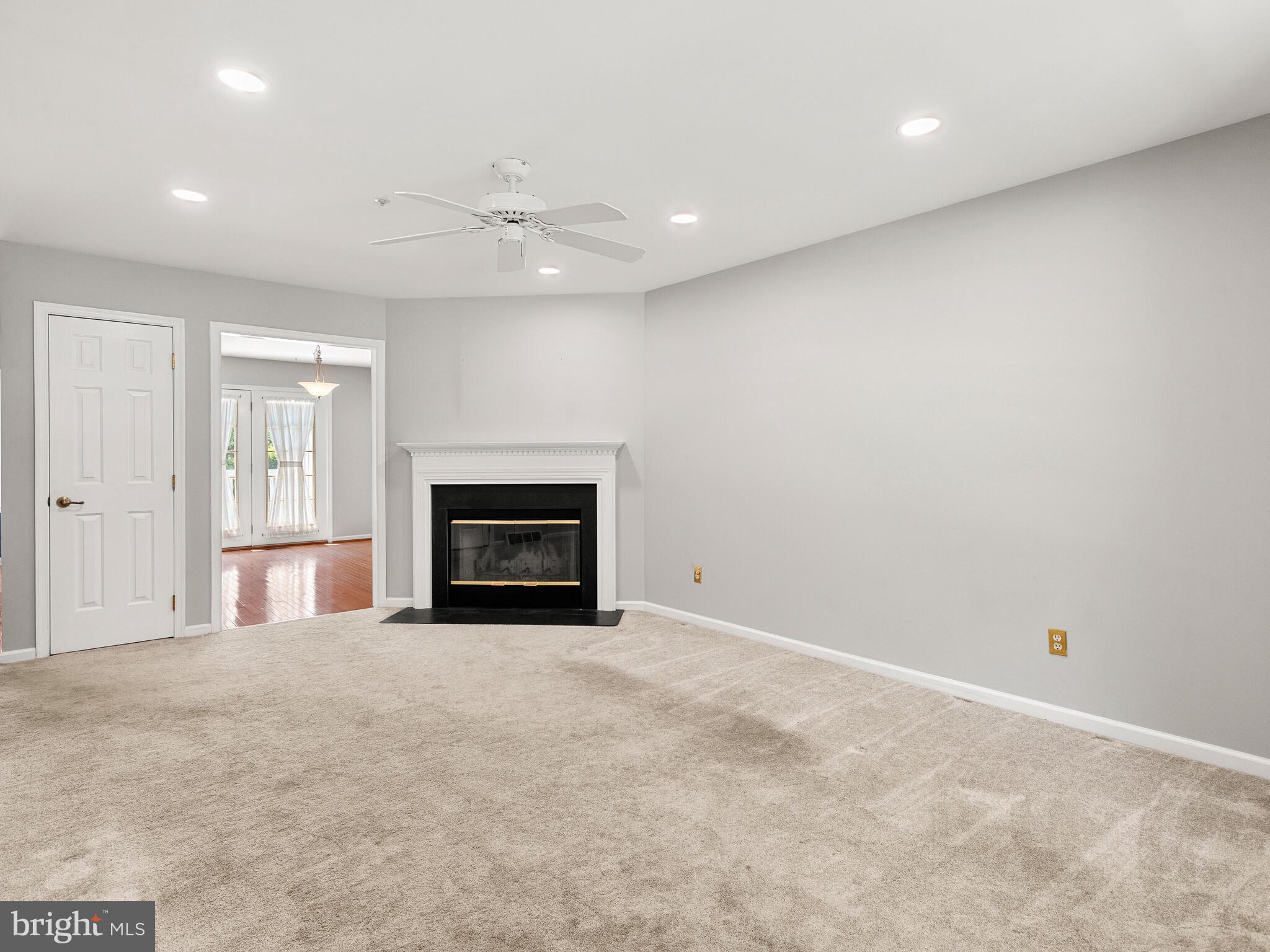 77 Buttonwood Drive, Unit 77 Exton, PA 19341 - Photo 9 of 29 an empty room with a fireplace and fan