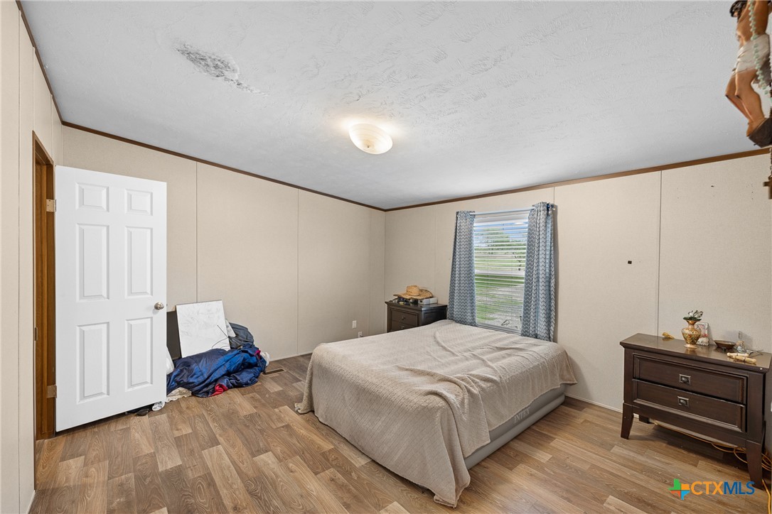 6497 Taylorsville Road Dale, TX 78616 - Photo 10 of 36 a bedroom with a bed and wooden floor
