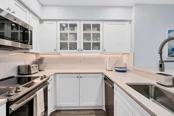 a kitchen with granite countertop a sink stove and cabinets