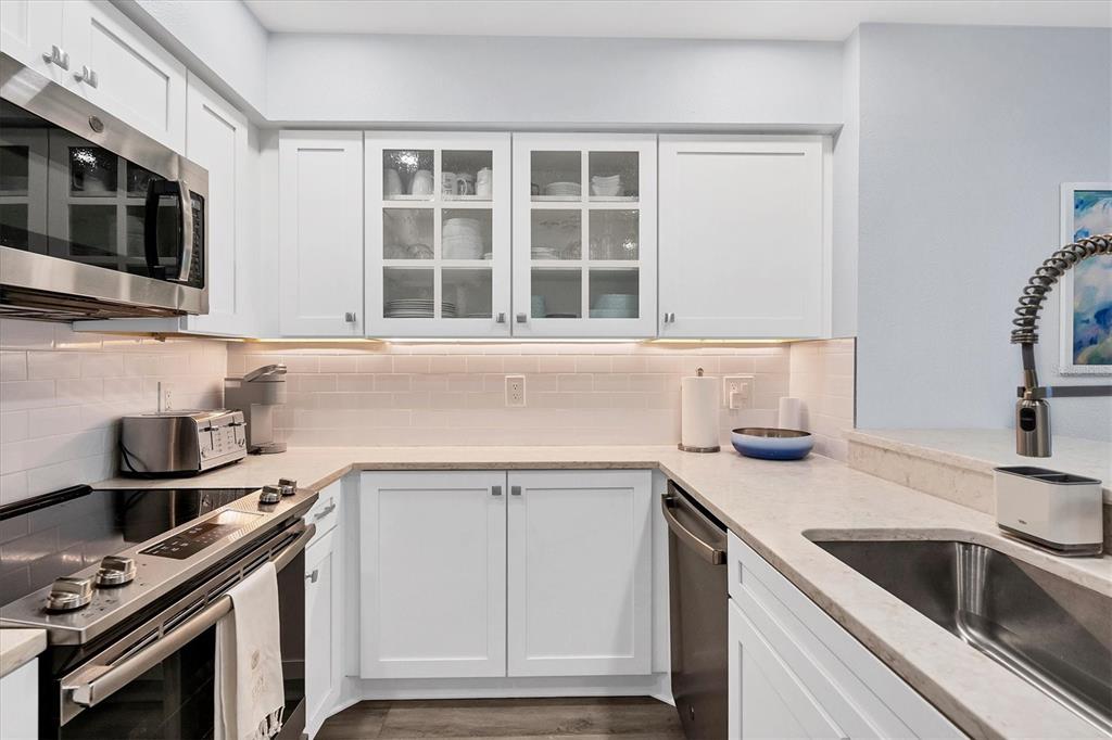 420 Gulf Boulevard, Unit 20 Boca Grande, FL 33921 - Photo 13 of 44 a kitchen with granite countertop a sink stove and cabinets