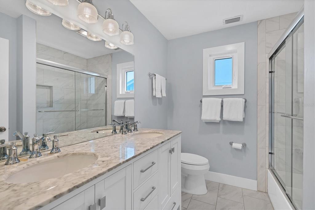 420 Gulf Boulevard, Unit 20 Boca Grande, FL 33921 - Photo 22 of 44 a bathroom with a granite countertop sink a toilet and a mirror