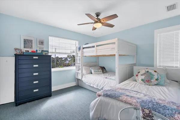 a bedroom with two bed and a window