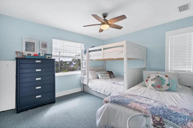 a bedroom with two bed and a window