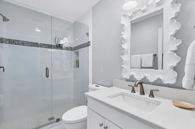 a bathroom with a sink toilet vanity and shower