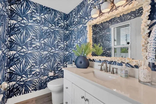 a bathroom with a granite countertop sink and a toilet