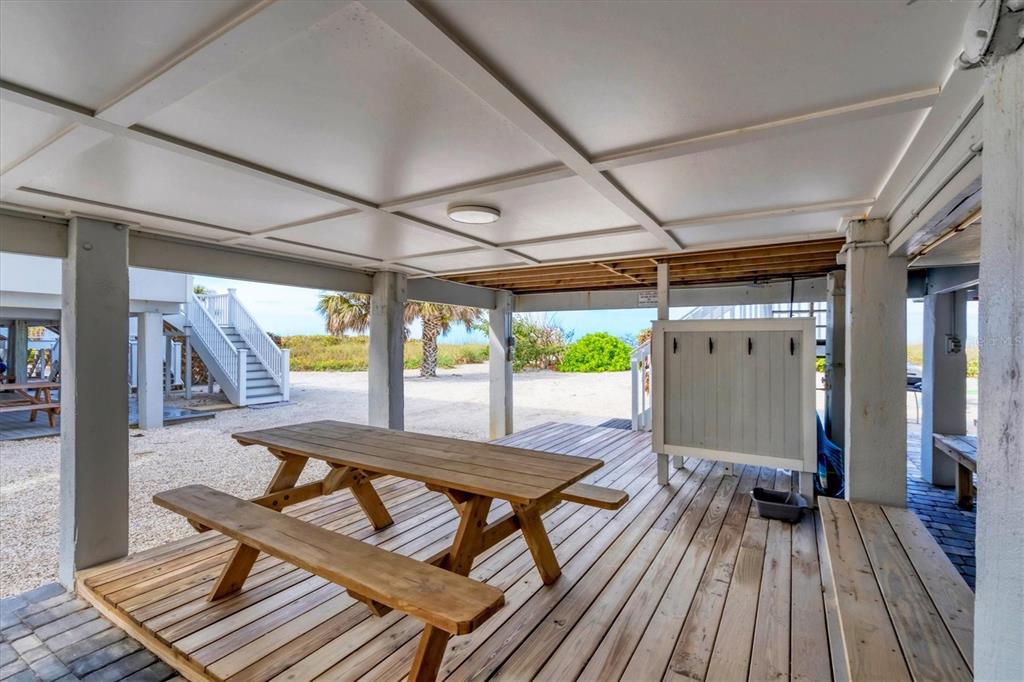 420 Gulf Boulevard, Unit 20 Boca Grande, FL 33921 - Photo 32 of 44 a view of a patio with table and chairs a wooden floor and a yard