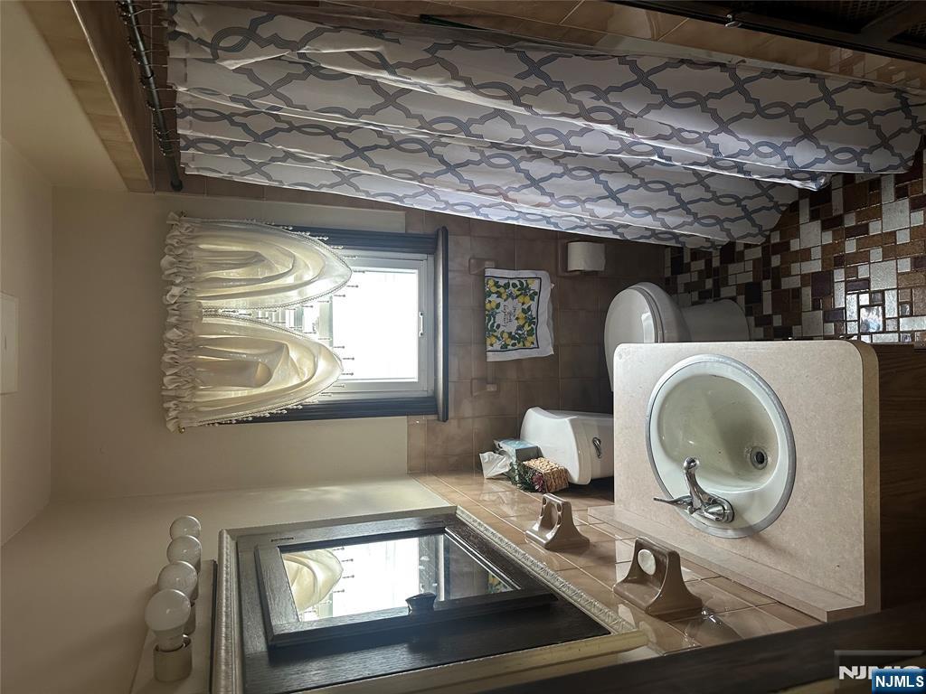 824 Paterson Avenue, Unit 2 East Rutherford, NJ 07073 - Photo 7 of 9 a bathroom with a sink toilet and mirror