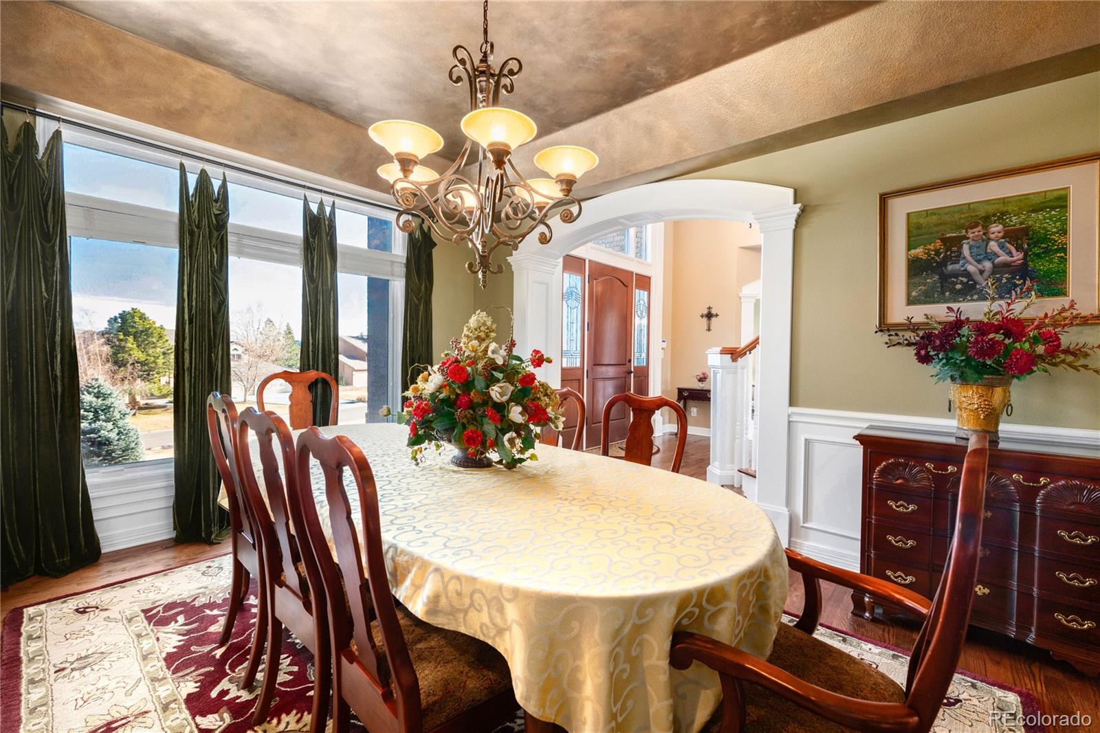 71 North Ranch Road Littleton, CO 80127 - Photo 11 of 40 a view of a dining room with furniture a chandelier and large windows