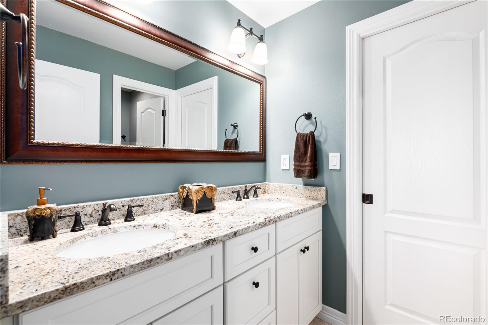 71 North Ranch Road Littleton, CO 80127 - Photo 28 of 40 a bathroom with a granite countertop sink and a mirror