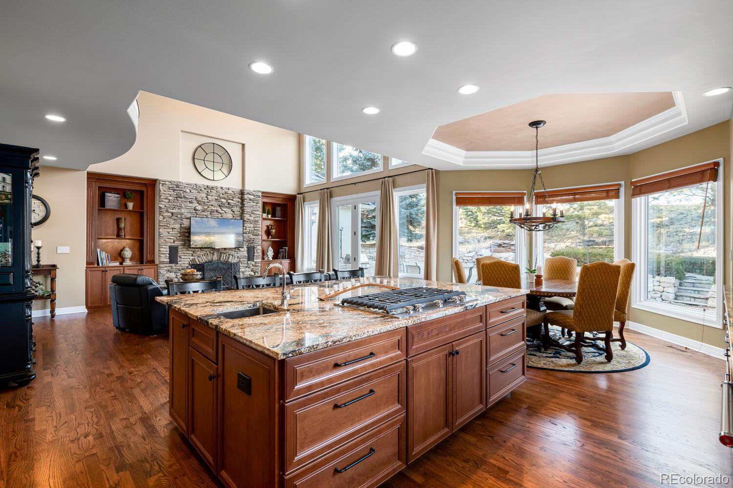 71 North Ranch Road Littleton, CO 80127 - Photo 3 of 40 a open kitchen with stainless steel appliances granite countertop a stove top oven a dining table and chairs with wooden floor