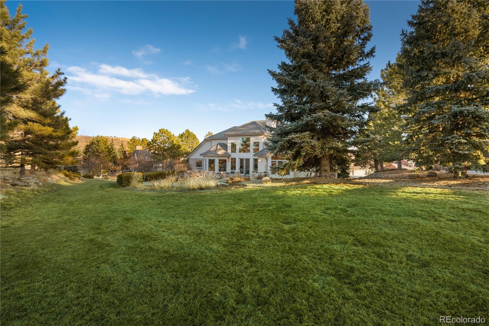 71 North Ranch Road Littleton, CO 80127 - Photo 8 of 40 a view of a big house with a big yard and large trees