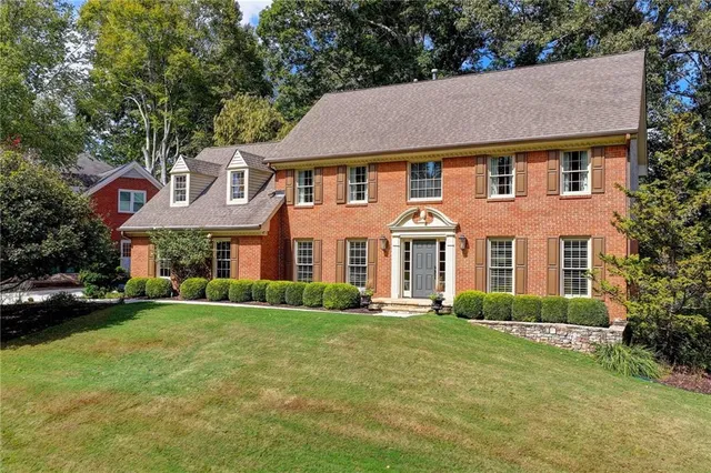 a aerial view of a brick house next to a yard