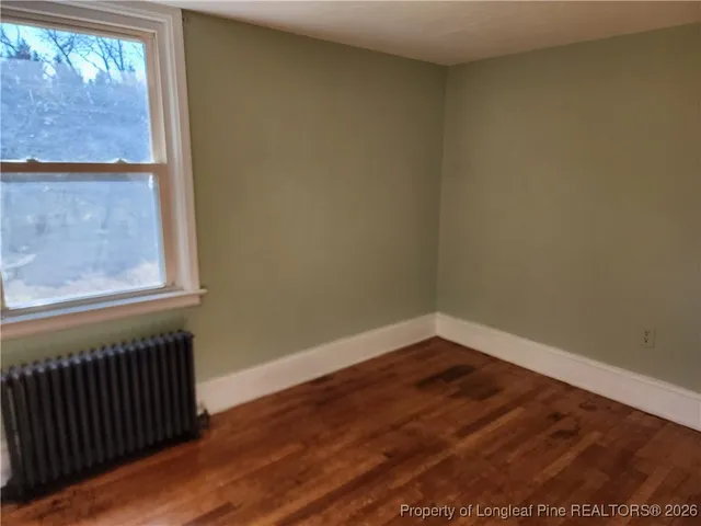 a view of a small space with wooden floor and a window