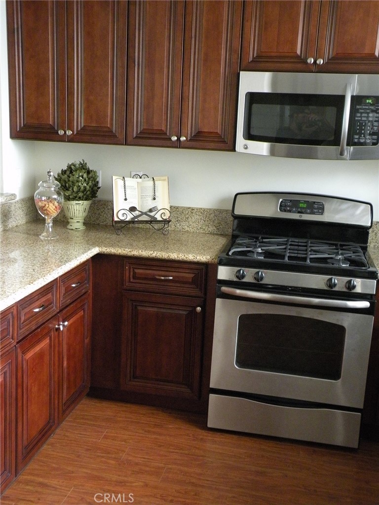 920 Central Avenue Riverside, CA 92507 - Photo 13 of 64 a kitchen with granite countertop wood cabinets and stainless steel appliances