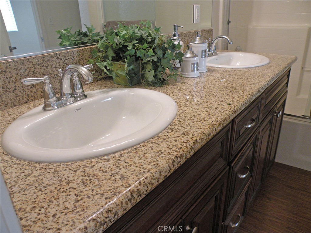 920 Central Avenue Riverside, CA 92507 - Photo 31 of 64 a bathroom with a granite countertop sink a mirror and vanity