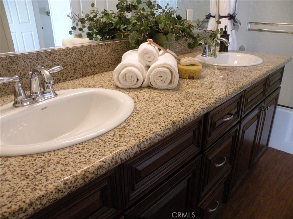 920 Central Avenue Riverside, CA 92507 - Photo 46 of 64 a bathroom with a granite countertop sink a mirror and vanity