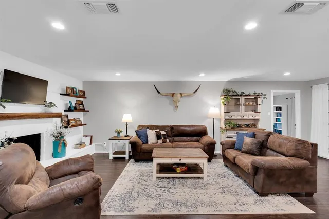 a living room with furniture a fireplace and a flat screen tv