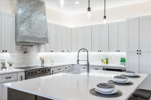 a kitchen with a white stove top oven a white counter space and a sink