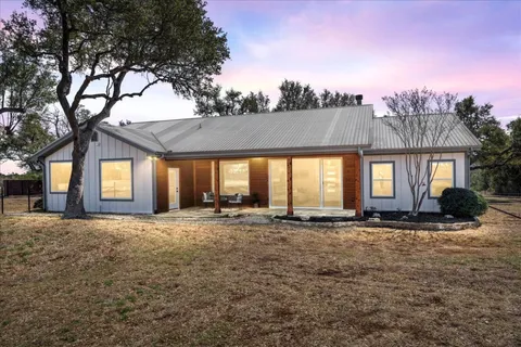 a view of a house with a yard and sitting area