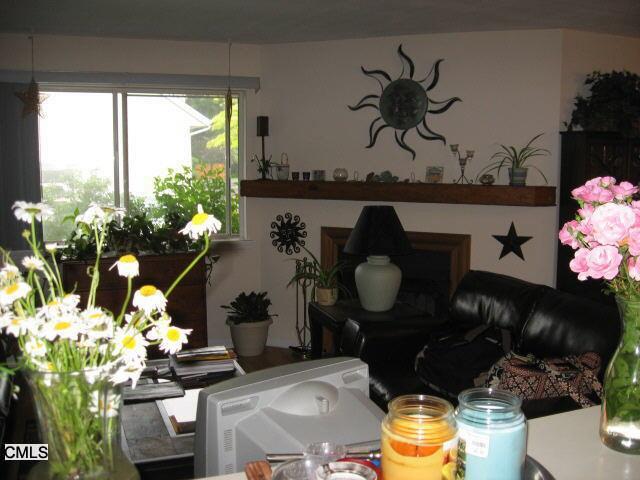 136 Pembroke Road, Unit 47 Danbury, CT 06811 - Photo 1 of 1 a vase of flowers sitting on a table with a fireplace