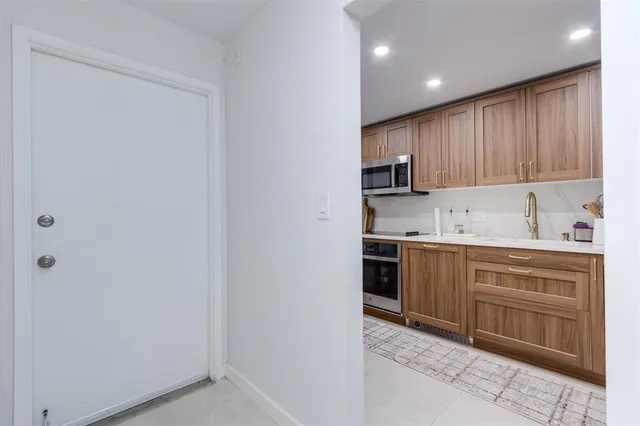 a kitchen with kitchen island granite countertop a sink cabinets and refrigerator