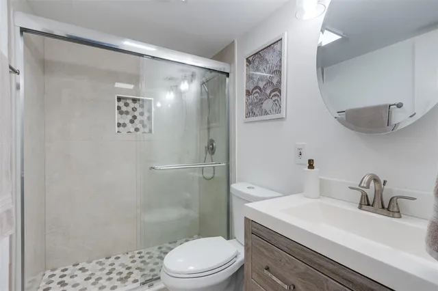 a bathroom with a sink and mirror with toilet