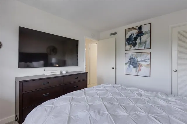 a bathroom with a toilet a sink a glass door a mirror and vanity