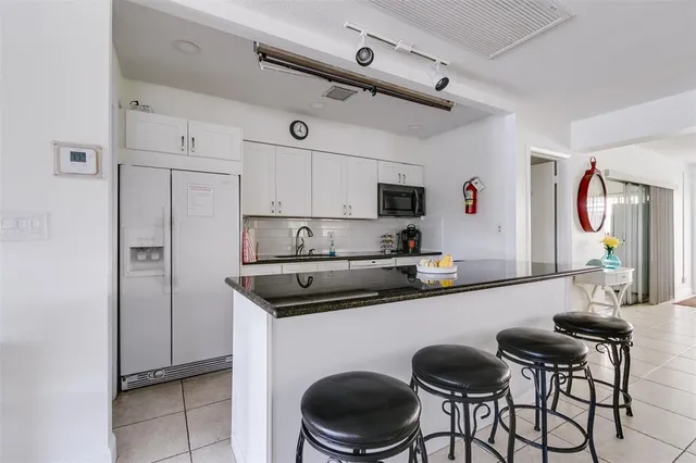 a room with wooden floors pool table and windows