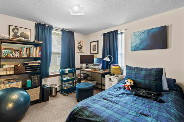 a kitchen with kitchen island a stove a sink a refrigerator and a dining table