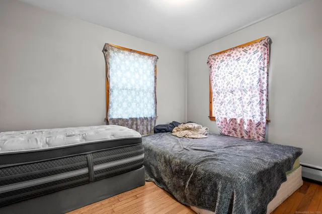 a bedroom with two beds and wooden floor
