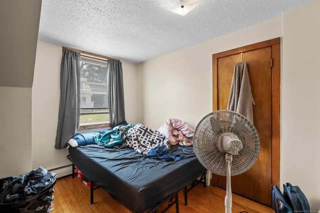 a bedroom with a bed and wooden floor