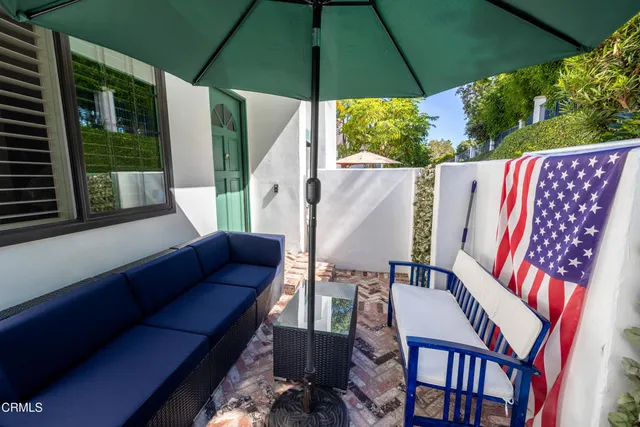 a view of an outdoor sitting area with furniture and umbrella