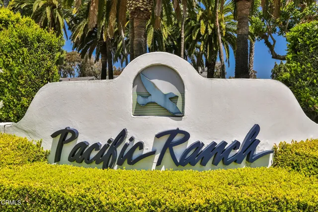 a view of swimming pool with lawn chairs and plants