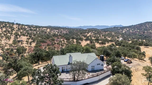 an aerial view of a house with a mountain in the background