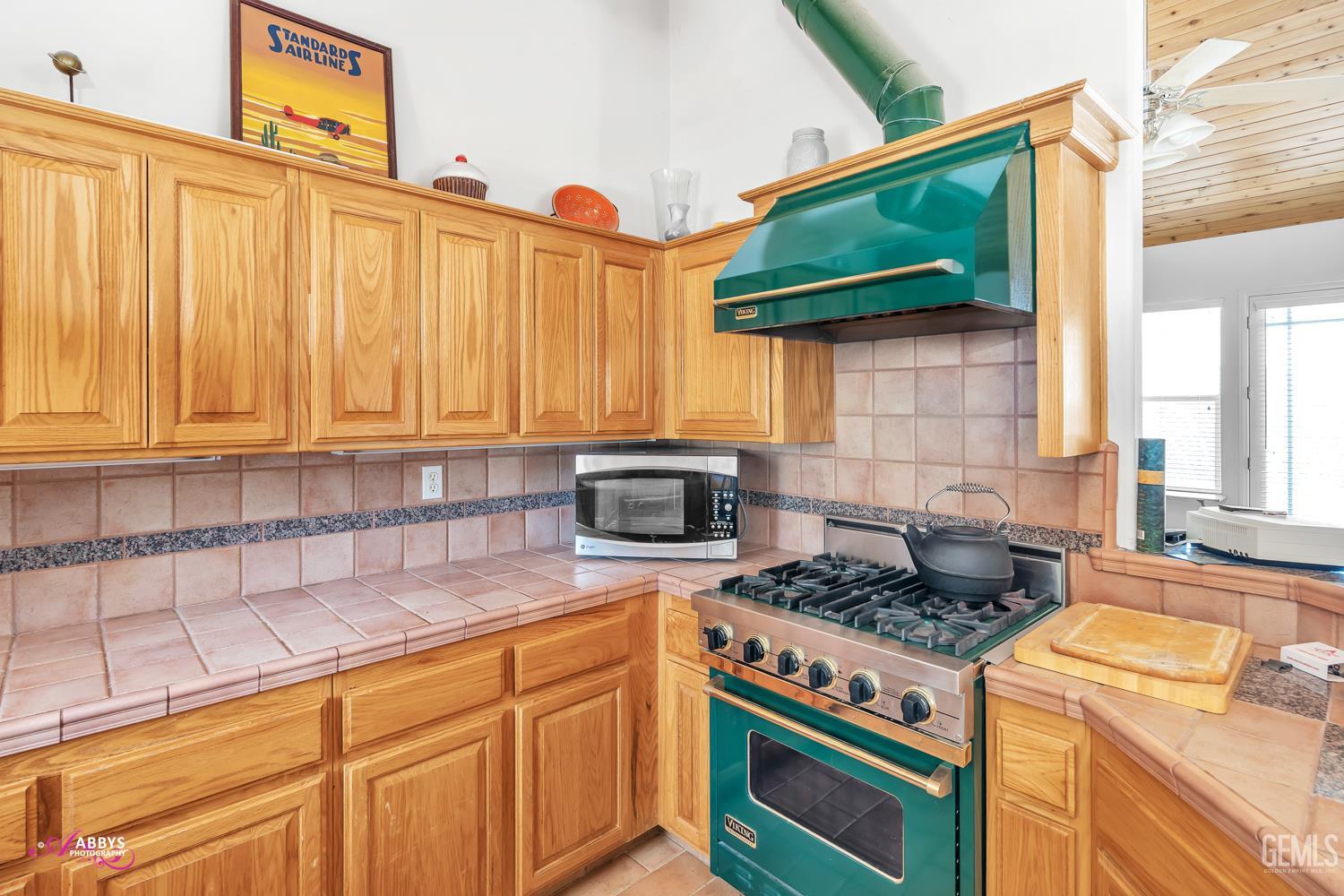 Undisclosed Address Woody, CA 93287 - Photo 9 of 30 a kitchen with granite countertop a stove a sink dishwasher and cabinets with wooden floor
