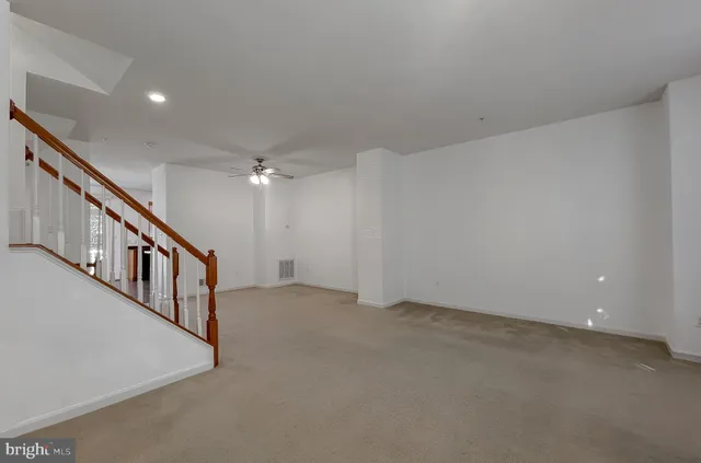 a view of staircase with wooden floor and fan